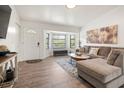 Inviting living room featuring wood flooring, a cozy sectional sofa, and natural light at 9080 Caloosa Dr, Venice, FL 34293