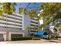 View of front entrance of the condos with palm trees and blue awning at 1000 Riverside Dr # B501, Palmetto, FL 34221