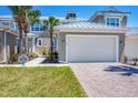 Charming townhome exterior with two-car garage, brick driveway, and lush lawn at 10720 Lemon Creek Loop # 103, Englewood, FL 34224