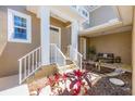 Inviting covered front porch with seating and garden area at 10720 Lemon Creek Loop # 103, Englewood, FL 34224