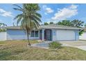 Charming single Gathering home with a well-manicured lawn, a palm tree, and an attached two-car garage at 108 Stanford Rd, Venice, FL 34293