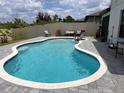 A beautiful blue swimming pool is decorated with lounge chairs and outdoor furniture at 1118 Wynnmere Walk Ave, Ruskin, FL 33570