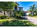 Inviting two-story home with lush landscaping, a brick-paved driveway, and a well-manicured lawn at 11510 Sweetgrass Dr, Bradenton, FL 34212