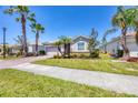 Inviting home with a brick driveway, lush landscaping, and palm trees in a tranquil neighborhood at 11702 Anhinga Avenue, Venice, FL 34292
