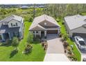 Aerial view of a well-maintained single-story home with beautiful landscaping and a brick driveway at 14265 17Th E Ct, Parrish, FL 34219