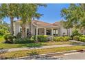 Attractive home featuring a covered front porch, well-manicured landscaping, and a serene neighborhood setting at 1520 Dorgali Dr, Sarasota, FL 34238