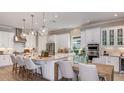 Bright, modern kitchen with white cabinets, stainless steel appliances, and pendant lighting over the island at 15408 San Lazzaro Ave, Bradenton, FL 34211