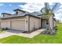 Charming single-story home with a neutral color palette, a tile roof, an attached garage and a meticulously landscaped front yard at 18016 Cherished Loop, Bradenton, FL 34211