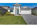 Inviting single Gathering home with a well manicured lawn, stone driveway, and eye catching plants at 18525 Midsummer Pl, Venice, FL 34293