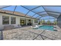 Enclosed pool area with in-pool loungers, outdoor grill, and covered patio at 1907 Woodleaf Hammock Ct, Bradenton, FL 34211