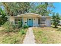 Inviting front exterior of the home with a blue door and well-maintained landscaping at 209 29Th Nw St, Bradenton, FL 34205