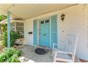 Charming front porch detail with a rocking chair, blue door and inviting decor at 209 29Th Nw St, Bradenton, FL 34205