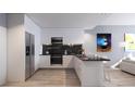 Modern kitchen with stainless steel appliances, sleek white cabinets, and black marble backsplash at 2170 Robinhood St # A1-302, Sarasota, FL 34231