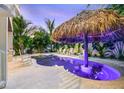Tropical backyard featuring custom pool, spa, tiki umbrella, pavers, white lounge chairs, and lush landscaping at 221 Grant Dr, Sarasota, FL 34236