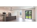 Open-concept kitchen featuring stainless steel appliances, tile floors and modern fixtures at 2231 Hagoplan Ln, North Port, FL 34288