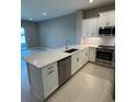 Elegant kitchen with stainless steel appliances and a large center island, flowing into an open living area at 24835 Buckingham Way, Port Charlotte, FL 33980