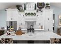 Bright kitchen boasts stylish backsplash, an island with seating, and modern appliances at 25305 83Rd E Ave, Myakka City, FL 34251