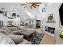 Bright living room with fireplace, vaulted ceiling, and open concept kitchen/dining area at 25305 83Rd E Ave, Myakka City, FL 34251