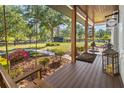 Inviting porch features wood flooring, a swing, and a 'welcome' sign creating a relaxing outdoor space at 25305 83Rd E Ave, Myakka City, FL 34251