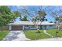 Charming one story home with beautiful yard, light blue exterior, and mature trees at 2932 Upper Tangelo Dr, Sarasota, FL 34239