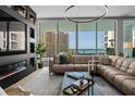 Bright living room with a large sectional sofa, modern fireplace, stylish decor, and expansive windows overlooking city and water views at 301 Quay Commons # 611, Sarasota, FL 34236