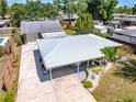 An aerial shot captures the home's layout, metal roof, lush backyard, and driveway at 3427 Cambridge Dr, Sarasota, FL 34232