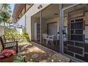 Cozy screened-in courtyard with comfortable seating, a small table, and views of well-maintained landscaping at 3500 El Conquistador Pkwy # 117, Bradenton, FL 34210