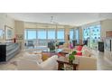 Spacious living room featuring floor-to-ceiling windows offering panoramic water views and stylish furnishings at 385 N Point Rd # 903, Osprey, FL 34229