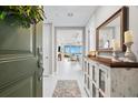 Inviting foyer features a decorative mirror, console table, and a view into the open-concept living area and water view at 388 Aruba Cir # 103, Bradenton, FL 34209