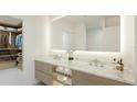 Bright bathroom features double sinks, a large illuminated mirror, and a walk-in closet for luxury and convenience at 4950 Remington Dr # 104, Sarasota, FL 34234
