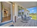 Inviting front porch featuring rocking chairs, a glimpse of the interior, and serene views at 5235 Spencer Parrish Rd, Parrish, FL 34219
