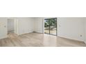 Living room featuring sliding glass door leading to backyard and new floors at 5414 Ansonia Ter, North Port, FL 34287