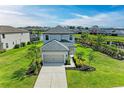 Two-story home with well-maintained lawn, garden beds and a driveway with mature palm trees at 5583 Summit Gln, Bradenton, FL 34203