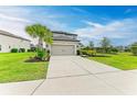 Home with driveway, landscaping, and gray exterior paint at 5583 Summit Gln, Bradenton, FL 34203