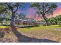 Spacious backyard featuring a screened lanai, beautiful lawn, and mature trees at 5711 Garden Lakes Fern, Bradenton, FL 34203