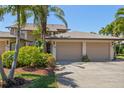 Attached two-car garage with neutral doors, providing ample parking and storage, set within well-maintained landscaping at 6780 Schooner Bay Cir # 6780, Sarasota, FL 34231