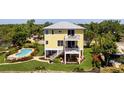 Charming yellow two-story home with balconies, lush landscaping, and a private pool at 6802 68Th E Ave, Bradenton, FL 34203