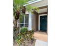 Charming covered entryway with green door, landscaping, and address number 102 at 7411 Vista Way # 102, Bradenton, FL 34202