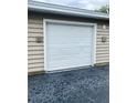 A well maintained single-car garage door with a clean, white finish and black asphalt driveway at 7411 Vista Way # 102, Bradenton, FL 34202