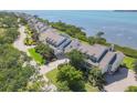 View of a long row of waterfront homes with well-manicured lawns, mature trees, and water views at 79 Tidy Island Blvd, Bradenton, FL 34210