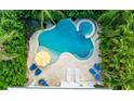 A tranquil pool with spa, surrounded by lush landscaping and lounge chairs at 113 8Th S St, Bradenton Beach, FL 34217