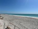 Wide sandy beach with calm ocean waters and stairs at 1190 Shore View Dr # C, Englewood, FL 34223
