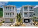 Beautiful new homes with garages and balconies, complemented by lush palm trees at 12415 Dockside Ter, Cortez, FL 34215