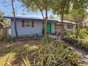 Charming home exterior with lush landscaping, green door and beautiful window shutters at 1350 40Th St, Sarasota, FL 34234