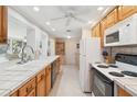 Bright kitchen with ample counter space, white appliances, and classic wooden cabinets at 1621 Overbrook Rd, Englewood, FL 34223
