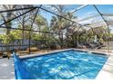 Screened-in pool area with cover offers a private oasis surrounded by lush landscaping at 1621 Overbrook Rd, Englewood, FL 34223