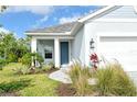 A front entrance with blue door, white pillars, and attractive landscaping adds curb appeal at 18249 Vizcaya Ct, Venice, FL 34293