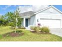 Charming entrance with blue front door, pavers, lush landscaping, and a well-manicured lawn at 18249 Vizcaya Ct, Venice, FL 34293