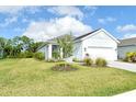 Landscaped front yard with green grass, trees, and plants accentuates this single Gathering home at 18249 Vizcaya Ct, Venice, FL 34293
