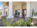 Charming front porch adorned with stone accents and ample seating at 20655 Valprato Ct, Venice, FL 34293